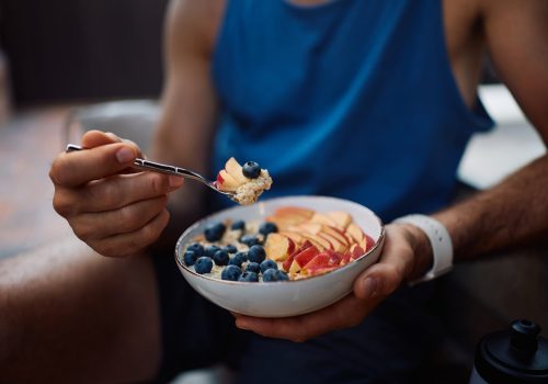 Close up of athlete eating healthy after sports training.